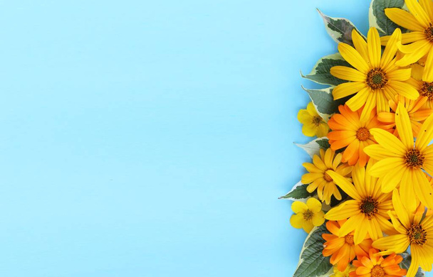 Yellow flowers on a blue background. Festive flower arrangement. Background for a greeting card. - 写真・画像