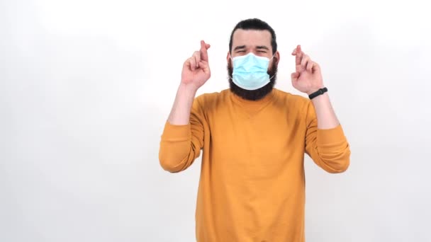 Beelden van een jonge man die vingers kruist en een medicinaal gezichtsmasker draagt - Video