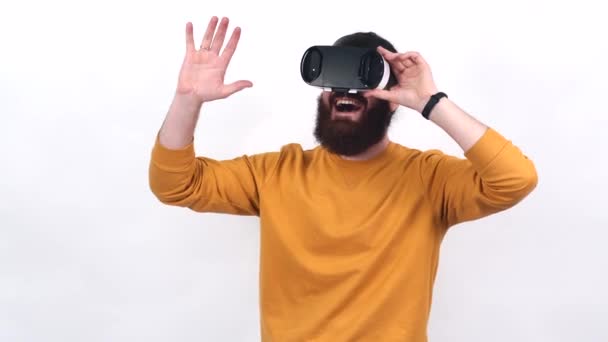 Кадри бородатого чоловіка в жовтому светрі, що мають віртуальну реальність з VR окулярами
. - Кадри, відео