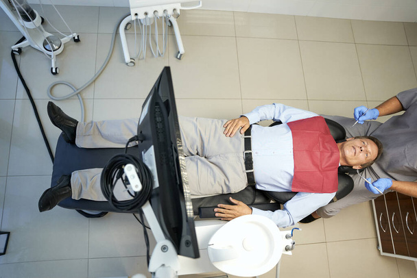 Foto de cuerpo entero del paciente masculino en silla de dentista - Foto, Imagen