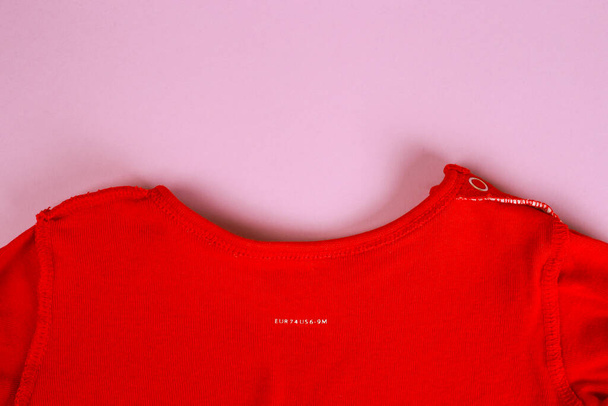 Детская одежда. Закрыть этикетку на текстильном фоне. Макет лейбла чистой одежды. 74 евро, 6-9 месяцев - Фото, изображение