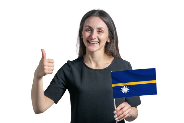 Felice giovane donna bianca che tiene la bandiera di Nauru e mostra la classe a mano isolata su uno sfondo bianco. - Foto, immagini