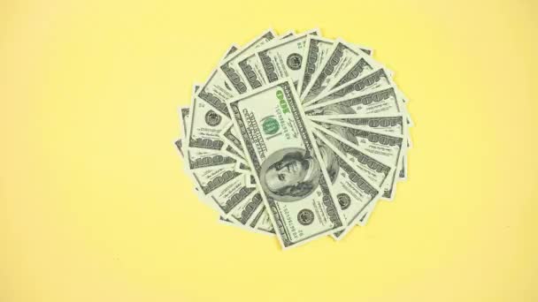 As notas de cem dólares americanos 4k giram em um círculo, e seu número está aumentando. Fundo amarelo. Conceito de dinheiro, ganhos e lucros crescentes. Pare a animação em movimento. Espaço de cópia. - Filmagem, Vídeo