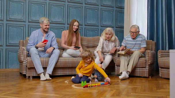 Happy multigeneration family leisure at home couple parents and grandpagents relaxing on sofa - Фото, изображение