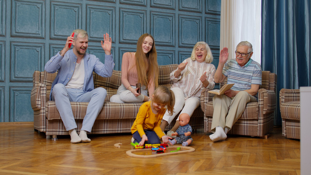 ocio familiar multigeneracional en el hogar, motivando gritos a niño niña jugando juguete ferroviario - Foto, imagen