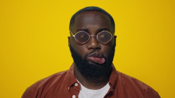 Portrait of afro handsome man making funny faces on yellow background. - Footage, Video