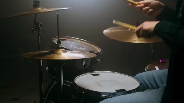 Dobos játszik a dob készlet egy sötét szobában egy fekete háttér. - Felvétel, videó