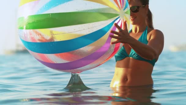 CLOSE UP: Touristin spielt im Sommerurlaub mit aufblasbarem Ball. - Filmmaterial, Video