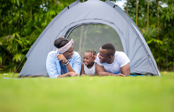 Famille afro-américaine joyeuse jouissant dans le parc, mère père et fille jouant au camping en plein air, concepts de famille Bonheur - Photo, image