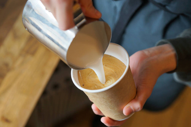 Barista prépare le cappuccino dans une tasse en papier - Photo, image