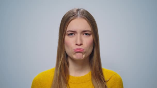 Portrait of beautiful girl making grimaces at camera on grey background. - Footage, Video