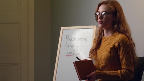 Ginger žena má on-line video obchodní školení drží knihu a mluvit s někým na kameře - Záběry, video