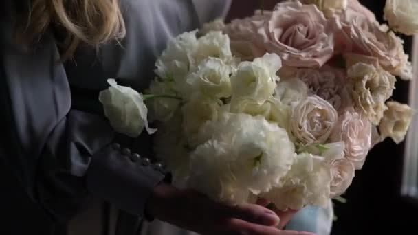 Young woman girl in the morning holding wedding bouquet of flowers. Bride with bridal roses and peonies - Imágenes, Vídeo