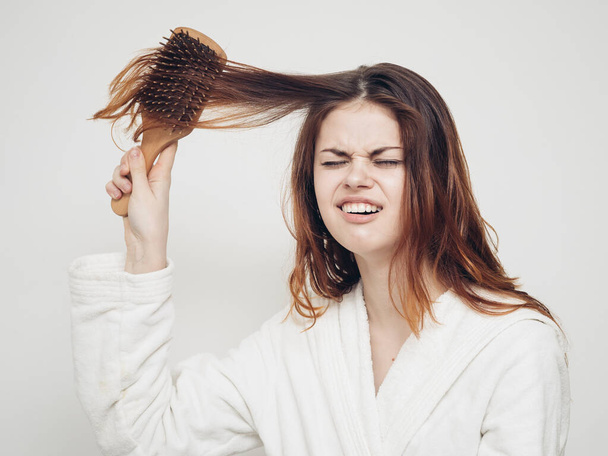 женщина держит расческу в руке и запутанные проблемы со здоровьем волос - Фото, изображение