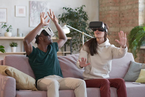 Couple jouant à la réalité virtuelle ensemble à la maison - Photo, image