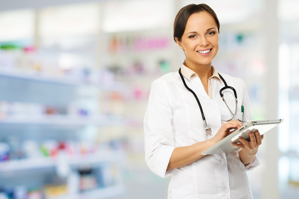 Nuori positiivinen brunette lääkäri nainen apteekissa tabletti pc
  - Valokuva, kuva