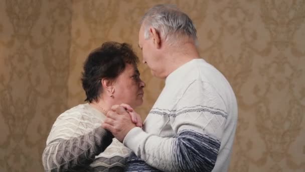 Happy mature married couple dancing at home in room, laughing and talking. Beautiful romantic elderly middle-aged grandparents have rest, have fun together, celebrate, enjoy caring, love, tenderness - Footage, Video