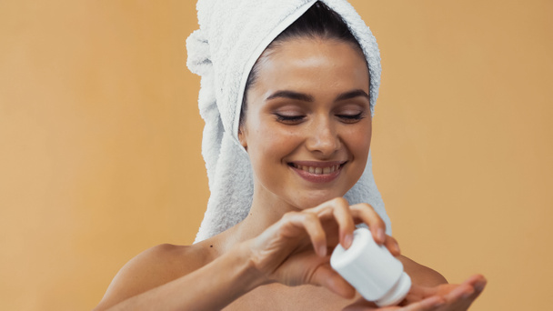 donna felice con asciugamano sul contenitore della testa con vitamine isolate sul beige - Foto, immagini