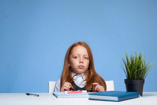 emocjonalna dziewczyna robi pracę domową w szkole stołowej nauka dzieciństwa - Zdjęcie, obraz