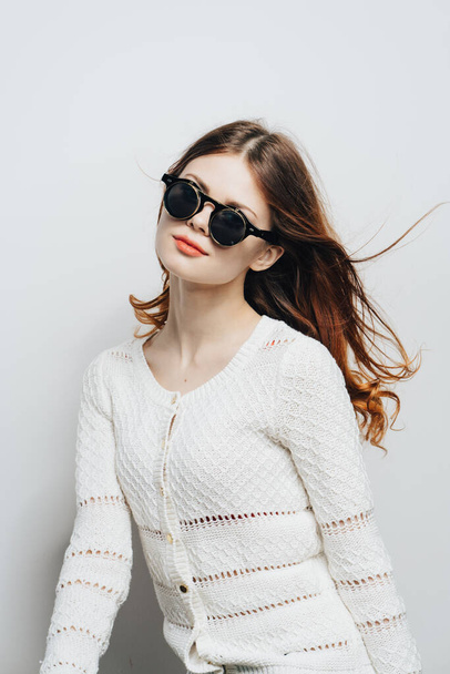 Woman in a white sweater with sunglasses studio fashion lifestyle glamor - Фото, изображение