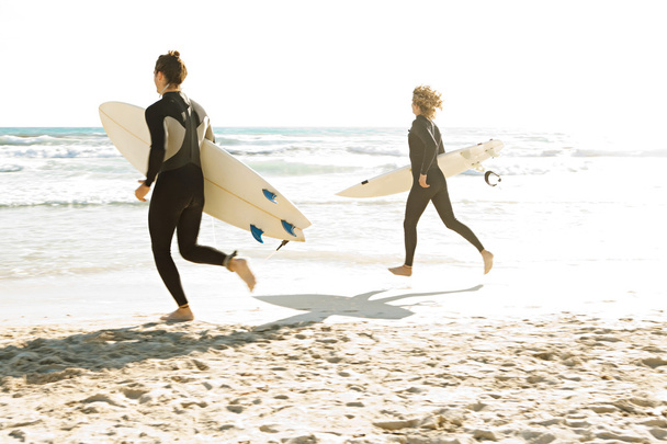 Surfistas corriendo juntos
 - Foto, Imagen