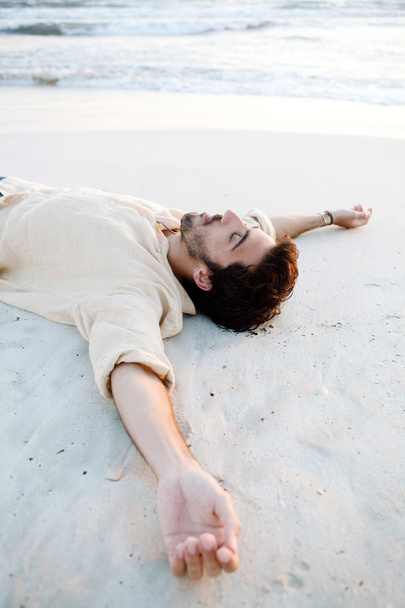 Чоловік лежить на пляжі
 - Фото, зображення