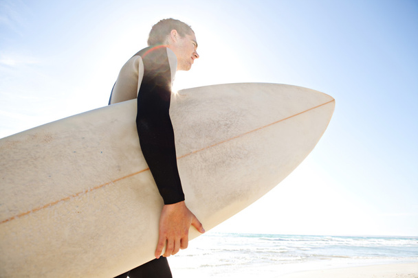 Surfista sosteniendo su tabla
 - Foto, imagen
