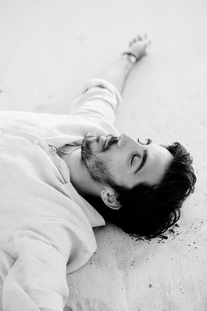Чоловік лежить на пляжі
 - Фото, зображення