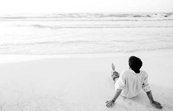Jovem sentado na praia
 - Foto, Imagem