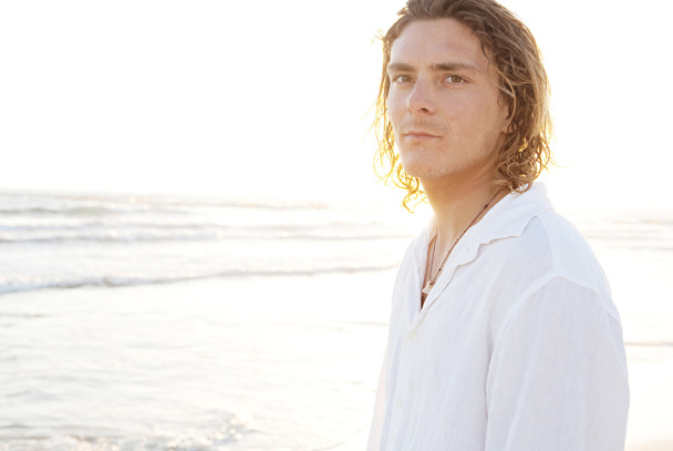 Nuori mies seisoo rannalla
 - Valokuva, kuva