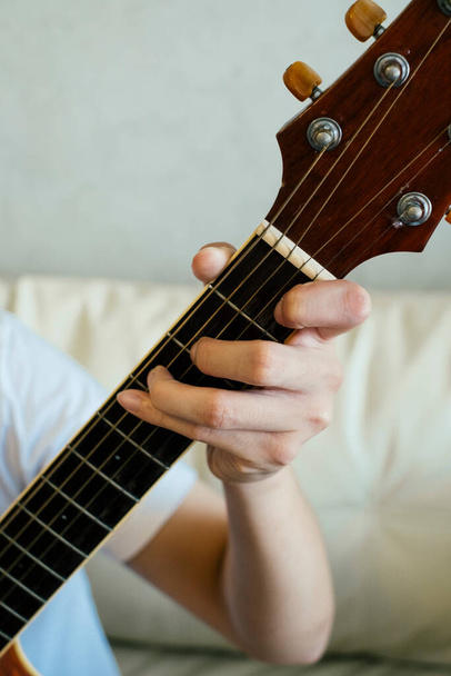 Chiudi le dita del chitarrista che suona la chitarra acustica. - Foto, immagini