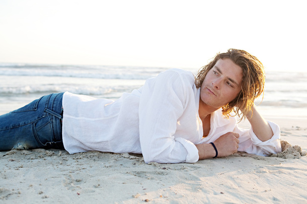 Homme allongé sur la plage
 - Photo, image