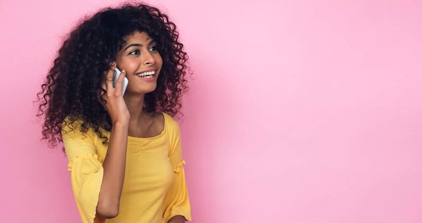 iloinen nuori nainen puhuu älypuhelimella eristetty vaaleanpunainen - Valokuva, kuva