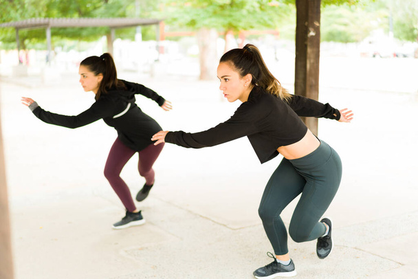 Des femmes attirantes qui font des limites latérales pendant une séance d'entraînement cardio au parc. Convient aux femmes latines qui font de l'exercice avec une routine HIIT à l'extérieur - Photo, image