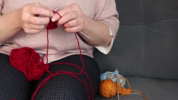 Donna che lavora a maglia con fili di lana rossa. Fatto a mano a casa. - Filmati, video