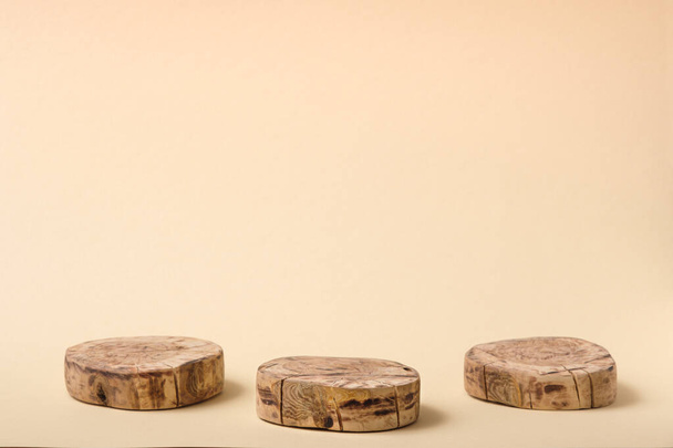 drei runde geschnittene Holzplattformen auf beigem Hintergrund, geometrisches Podium, Sockel, Attrappe, Ökoszene zur Präsentation von Schönheitsprodukten, Attrappe - Foto, Bild