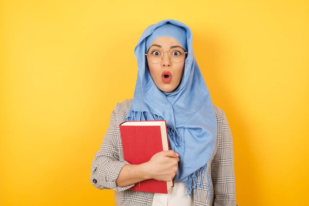 Fejlövés ostoba meglepett fiatal muszlim nő visel hidzsáb és alkalmi ruhák, bámult kamera sokkolt megjelenés, kifejező csodálkozás és sokk, sikoltozó Omg vagy Wow - Fotó, kép