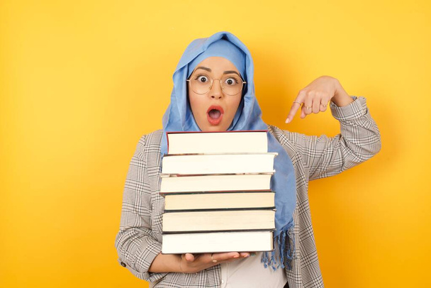 fiatal muszlim nő visel hidzsáb mutató könyvek - Fotó, kép