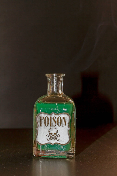 Conceito de coisa tóxica. Frasco transparente com líquido roxo simulando veneno. A etiqueta diz veneno, juntamente com um crânio e duas tíbias - Foto, Imagem