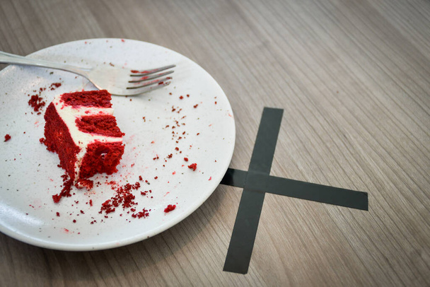 sobrante pastel de terciopelo rojo en la mesa de madera con marca de distanciamiento social - Foto, imagen