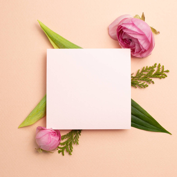 Almohadilla de notas en blanco con flores ranúnculos sobre fondo rosa. plano, vista superior, espacio para copiar - Foto, Imagen