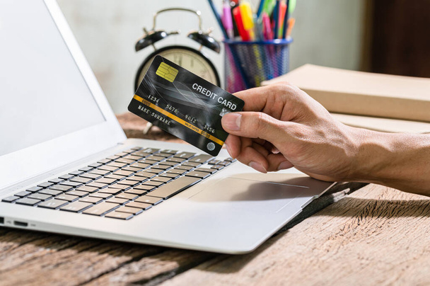 As pessoas usam cartões de crédito para fazer compras online através de computadores notebook. - Foto, Imagem
