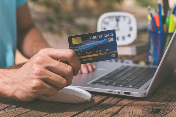 Az emberek hitelkártyákkal vásárolnak online a notebook számítógépeken keresztül.. - Fotó, kép