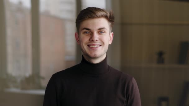 Close-up male friendly face, portrait caucasian millennial guy business man freelancer student model looking at camera standing posing at home office indoor, smiling wide, confident young entrepreneur - Footage, Video