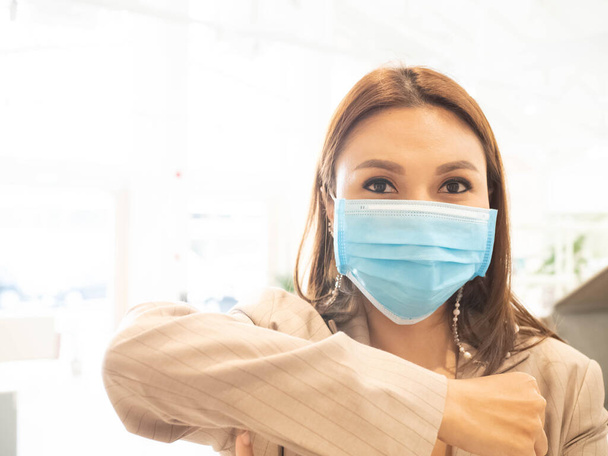 Керівник офісу компанії бізнес-леді ліктьовий насос африканський погляд на камеру носить блакитну ізольовану маску для захисту від грипу ковадлової вірусної хвороби 2019 року.
 - Фото, зображення