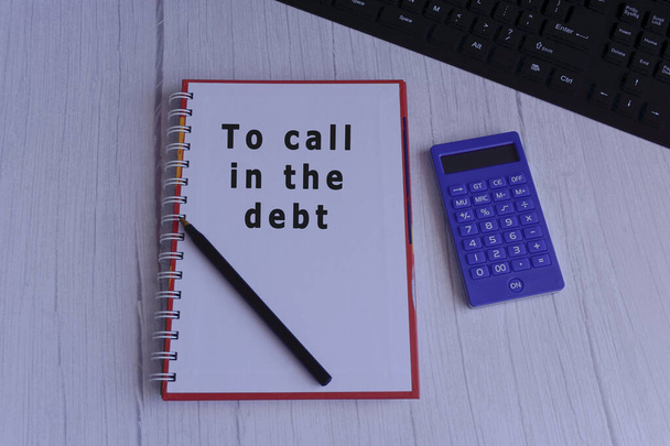 Κείμενο στο σημειωματάριο με pend, αριθμομηχανή και πληκτρολόγιο - Για να καλέσετε το χρέος - Φωτογραφία, εικόνα