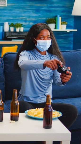 Mixed race women with protection mask playing video game - Photo, Image