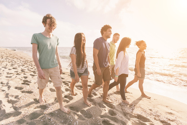 multirassische Gruppe von Freunden zu Fuß am Strand - Foto, Bild