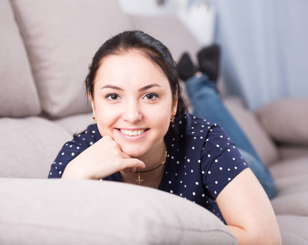 Smiling brunette lying on sofa - Fotó, kép