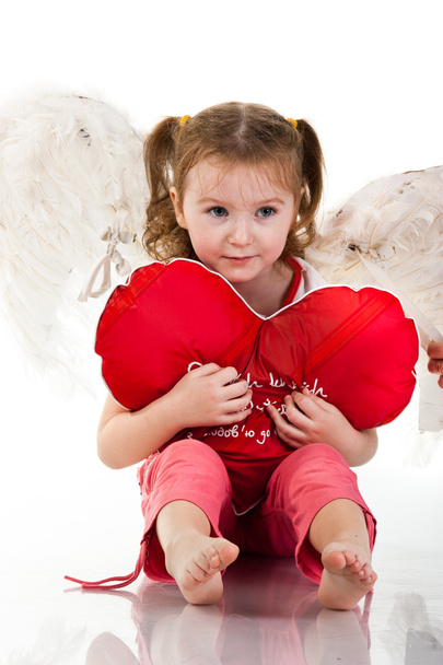 Beautiful girl sitting with heart shaped red pillow - Φωτογραφία, εικόνα